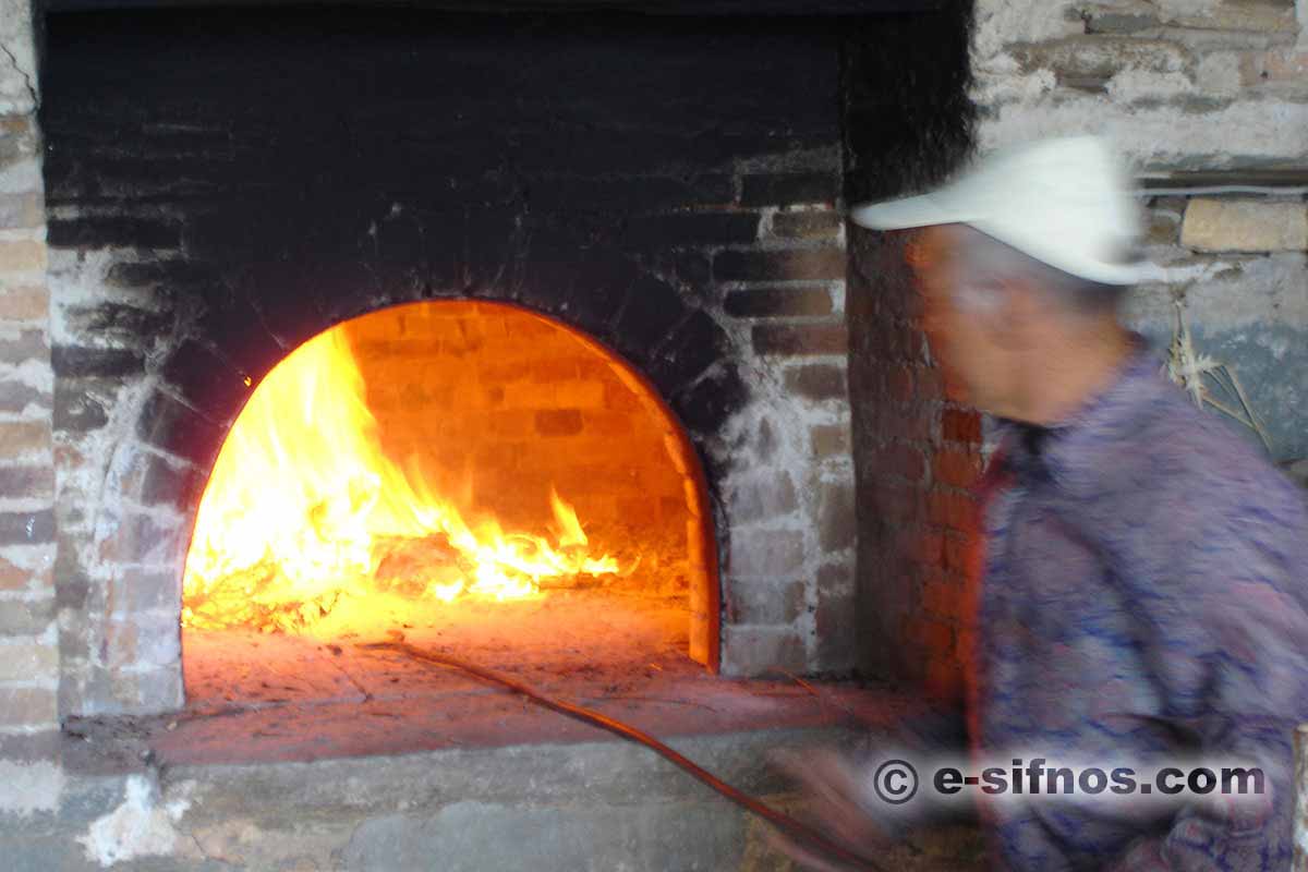 Preparing the wood oven, for the traditional easter food mastelo, in Sifnos